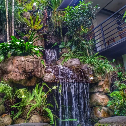 big waterfall beside a modern house