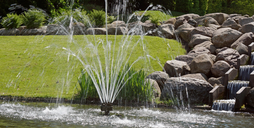 simple fountain in the middle of a pond